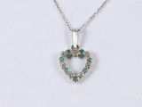 an image of a heart shaped pendant with green stones on a chain