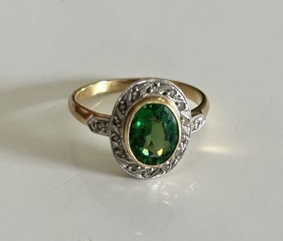 a close up of a ring with a green stone in it
