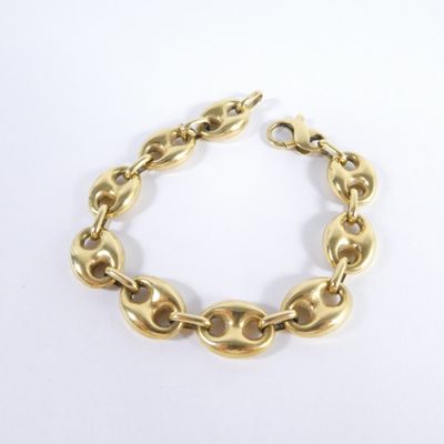 a close up of a gold bracelet on a white surface