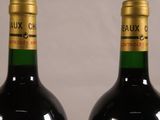 two bottles of wine sitting next to each other on a table