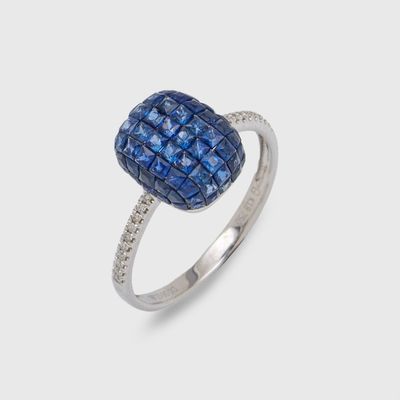 a close up of a diamond and sapphire ring on a white background