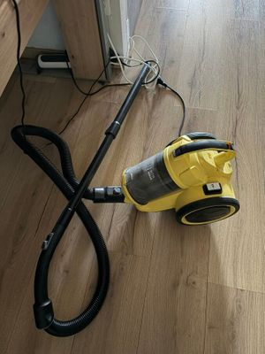 un aspirateur posé par terre à côté d'une table
