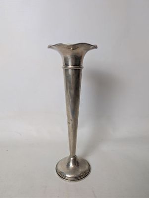 a silver vase that is sitting on a table