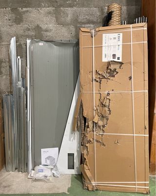 une pile de cartons et un réfrigérateur dans un coin de la pièce