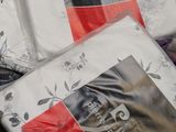 a pile of white and red bedding on a bed