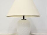 a white table lamp with a white shade on it