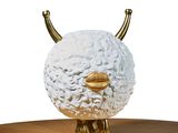 a white and gold sculpture of a sheep on a table
