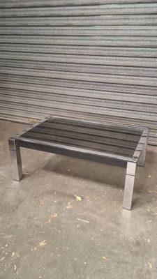 a metal bench sitting in front of a garage door