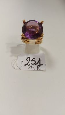 Gros plan sur une bague ornée d'une pierre violette
