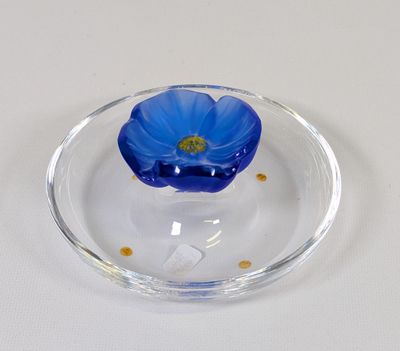une plaque de verre ornée d'une fleur bleue