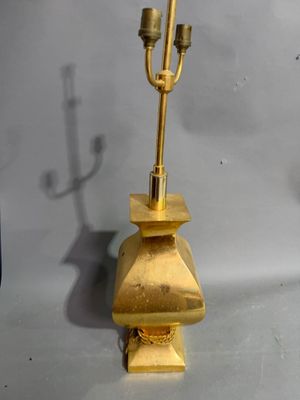 pair of brass candlesticks with a brass base and a brass candle holder