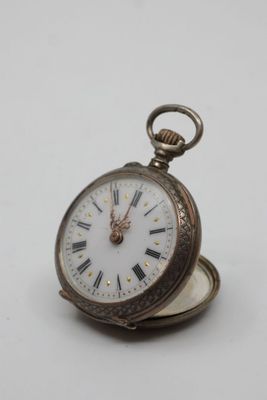 a silver pocket watch with roman numerals on it