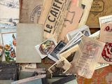 a pile of old books on the floor next to a suitcase