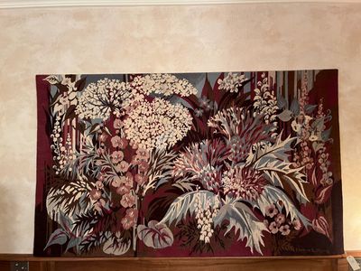 une grande tapisserie accrochée au mur au-dessus d'un lit