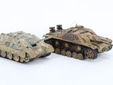 two toy tanks sitting next to each other on a white surface