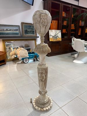 une statue au milieu d'une pièce, avec une télévision en arrière-plan