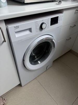 a washing machine in the corner of a kitchen
