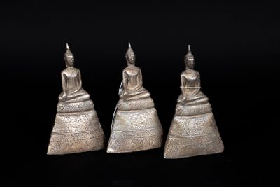 three silver buddha figurines sitting on top of each other
