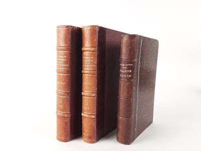 two old books sitting on top of each other on a white surface