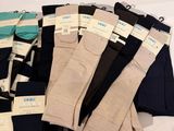 several pairs of men ' s socks are stacked on a white surface