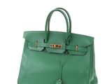 a green leather handbag on a white background