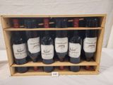 des bouteilles de vin rouge dans un casier à vin en bois posé sur une table