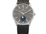 La montre est en acier inoxydable et est dotée d'un bracelet en cuir marron