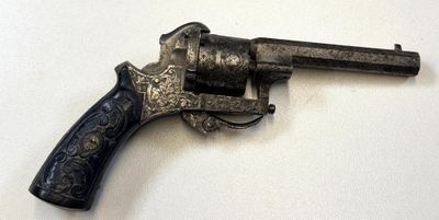 un pistolet posé sur une surface blanche
