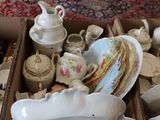 a box full of tea cups and saucers on the floor