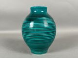 une image représentant un vase vert sur fond blanc