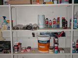 a room with a lot of paint and supplies on the shelves
