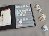 un livre ouvert sur lequel sont collés des timbres et un tas de timbres éparpillés sur le sol
