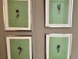 trois photos de fleurs encadrées sont accrochées au mur au-dessus des toilettes