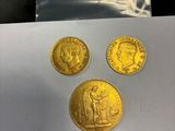 trois pièces d'or posées sur un morceau de papier