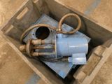 a blue water pump sitting in a box on the ground