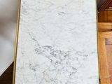 an image of a marble table with a gold frame on it