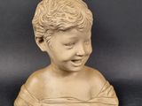 marble bust of a boy with curly hair on a black background