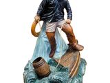 figurine of a fisherman on a boat with a net