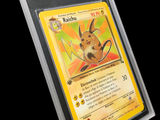 La carte Pokémon se trouve dans un étui en plastique transparent sur fond noir.
