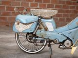 a blue motorcycle parked in front of a brick wall