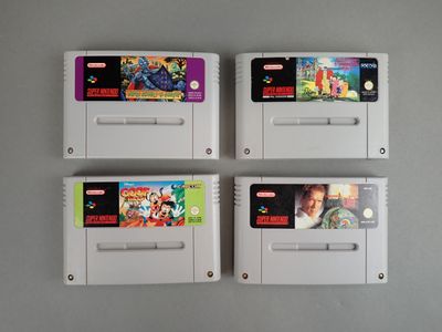 trois cartouches de jeux Nintendo posées sur une table blanche