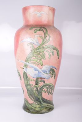 un vase rose orné d'une peinture représentant des oiseaux