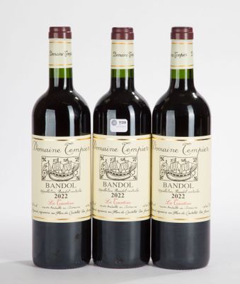 trois bouteilles de vin rouge posées l'une à côté de l'autre sur une surface blanche