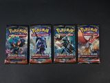 trois paquets de cartes à collectionner Pokémon posés sur une table