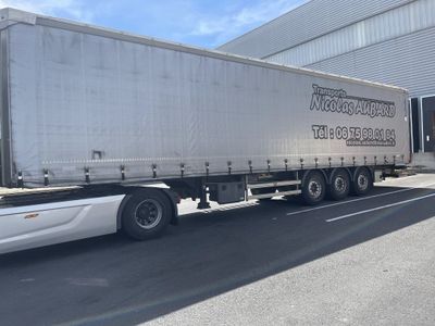 a truck that is driving down the street in front of a building