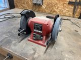 a red grinder on a workbench in a workshop