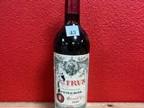 a bottle of red wine sitting on top of a wooden table