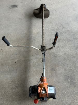 une trottinette posée par terre, avec une poignée fixée dessus