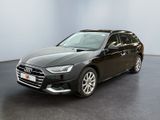Une Audi noire est garée dans une pièce aux murs blancs