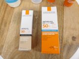 bottles of sunscreen and lotion sitting on a table next to a bottle of lotion